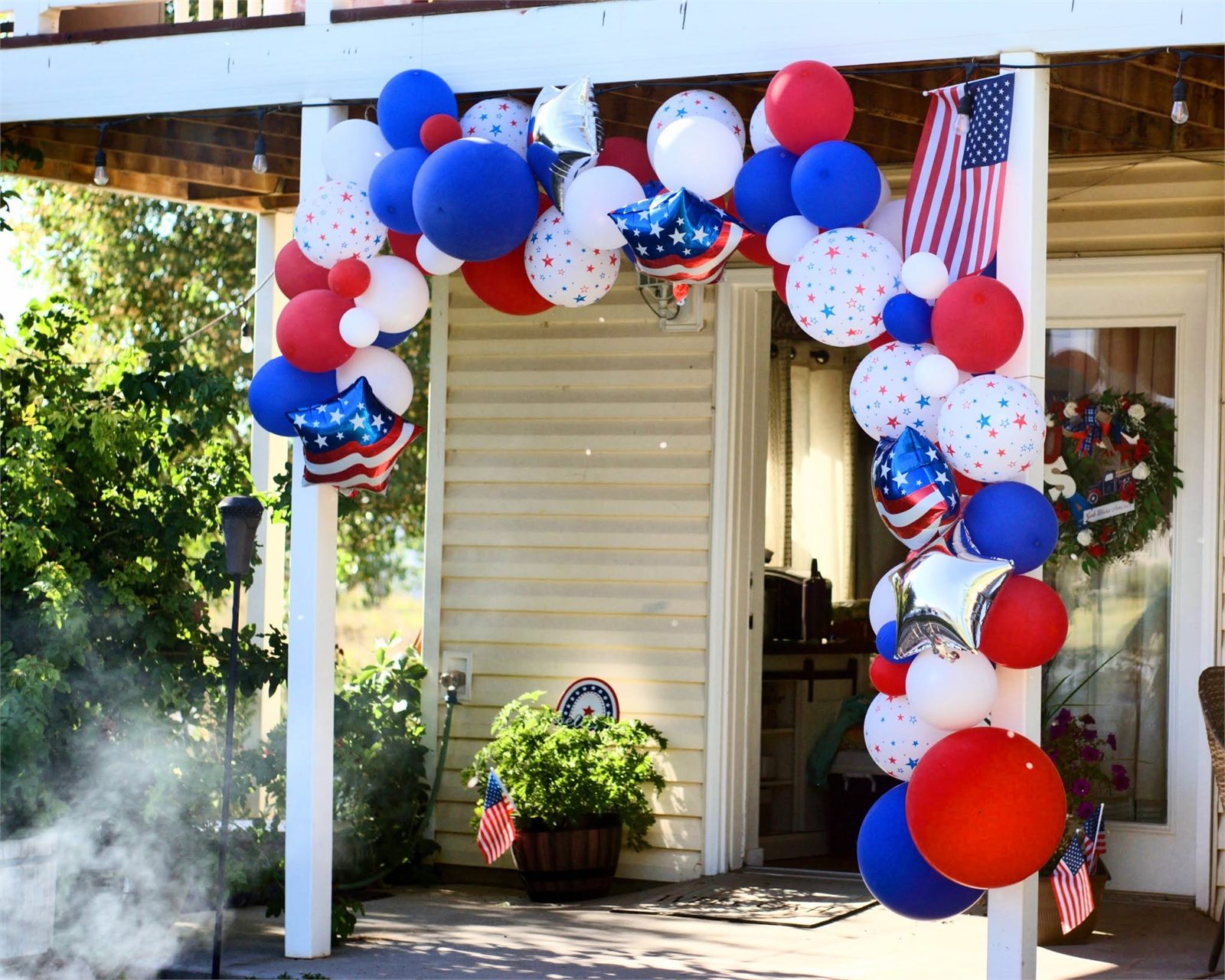 Red white and blue balloon garland over a porch